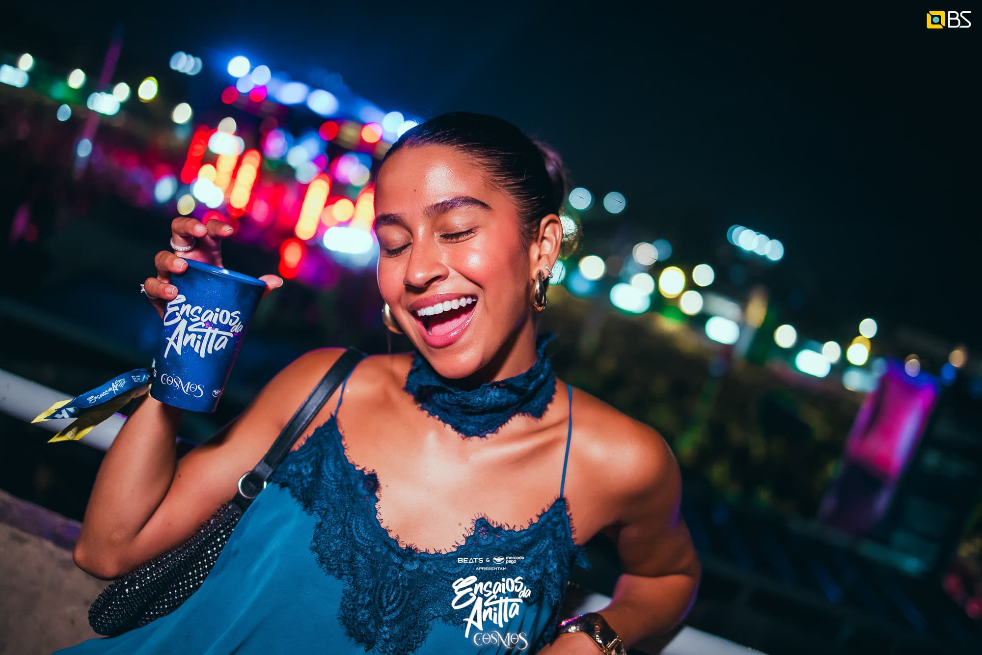 Pessoa sorrindo com um copo Ensaios da Anitta